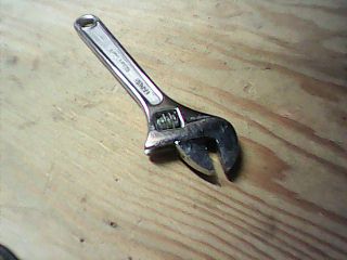 Actual ESP32-S3 camera photograph of an adjustable wrench on a wooden workshop bench